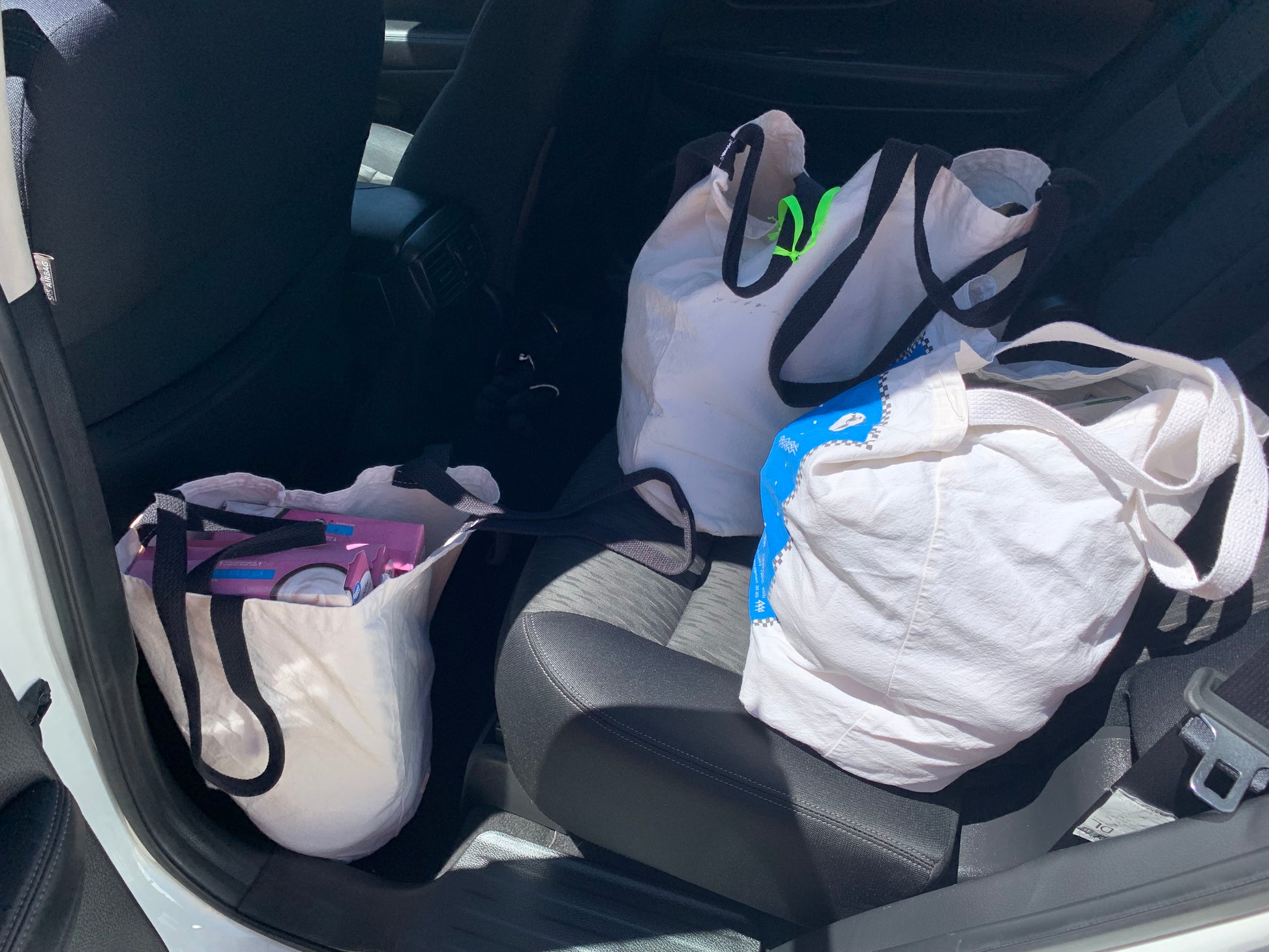 Each Bag Has Been Custom Designed. Every Bag is Sewn by Hand and Made In The USA from Recycled Cotton and Recycled Plastic Bottles. Large enough to hold ALL your groceries. Comes with two handles in 13-inch and 25-inch lengths. View from Backseat of car full of groceries.